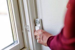Момент установки привода для штор на стену рядом с окном.